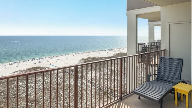 Un balcon avec vue sur une plage et l’océan.