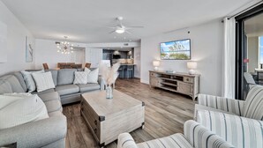 A modern living room with a sectional sofa, a coffee table, and a TV.