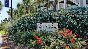 A sign for 'Sea Cabins' with a lush garden in front. - Outstanding Oceanfront Condo with Private Balcony! (Isle of Palms)