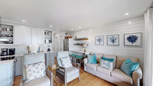 A compact living space with a kitchenette, a sofa set, and a coffee table. - Outstanding Oceanfront Condo with Private Balcony! (Isle of Palms)