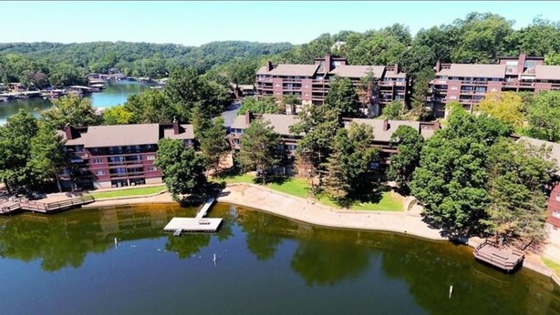 A multi-story hotel with a central courtyard and a lake.