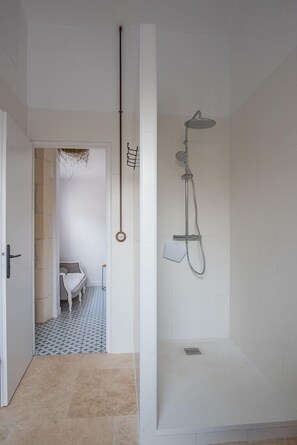Een bad/douchecombinatie, een haardroger, zeep, toiletpapier