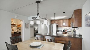 Une cuisine moderne avec des meubles en bois, un îlot central et des luminaires suspendus.