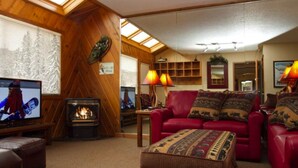 A cozy living room with a fireplace, leather sofa, and a television.