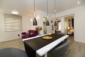 شقة ديلوكس | منطقة المعيشة | تلفزيون بشاشة مسطحة بحجم 35-بوصة يعرض قنوات تلفزيونية باشتراك مدفوع