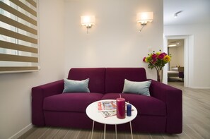 شقة ديلوكس | منطقة المعيشة | تلفزيون بشاشة مسطحة بحجم 35-بوصة يعرض قنوات تلفزيونية باشتراك مدفوع