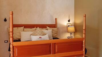 Ein Himmelbett mit Holzgestell und einer Matratze darunter.