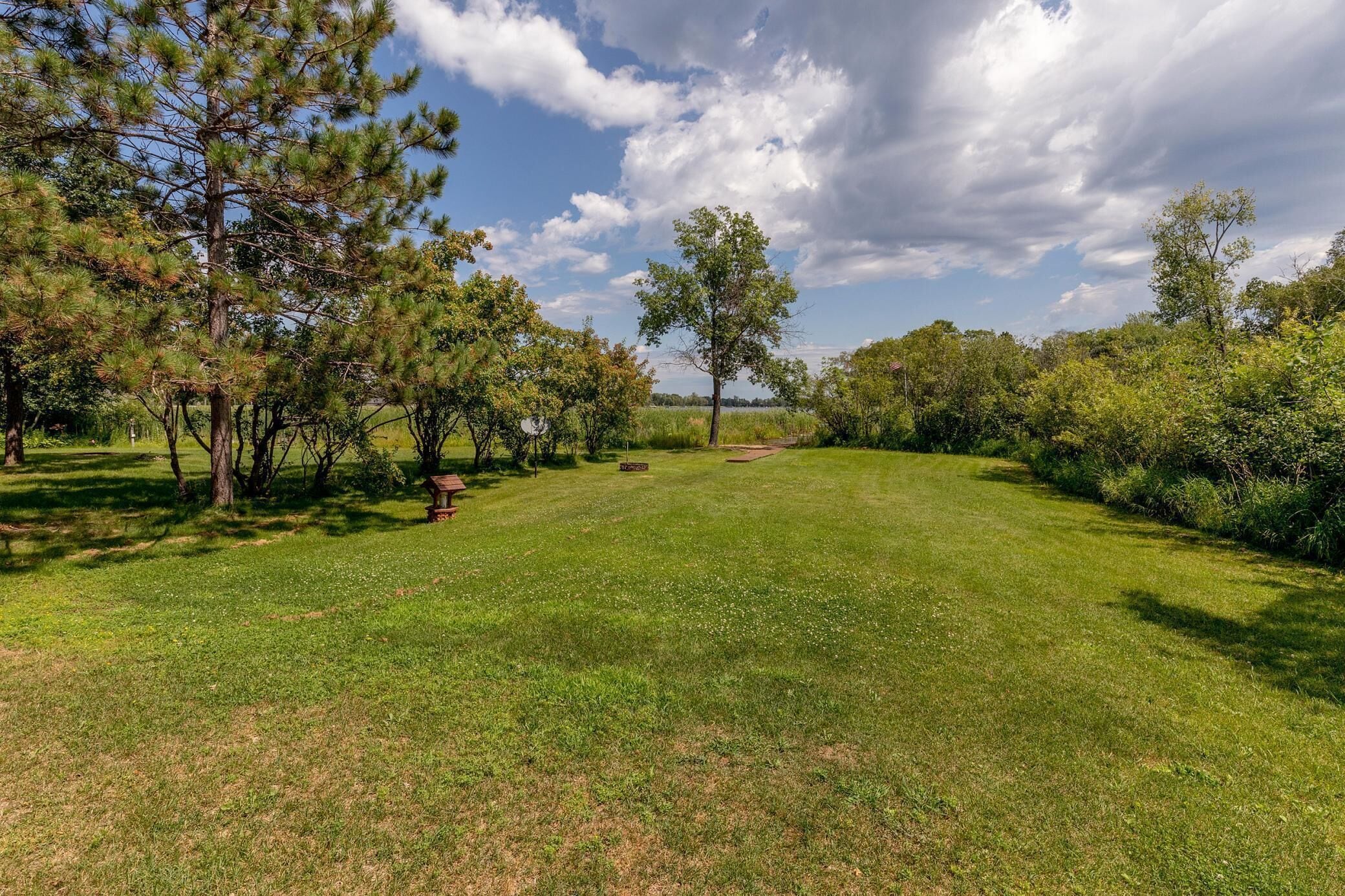 A well-maintained grassy area with trees and a clear sky.