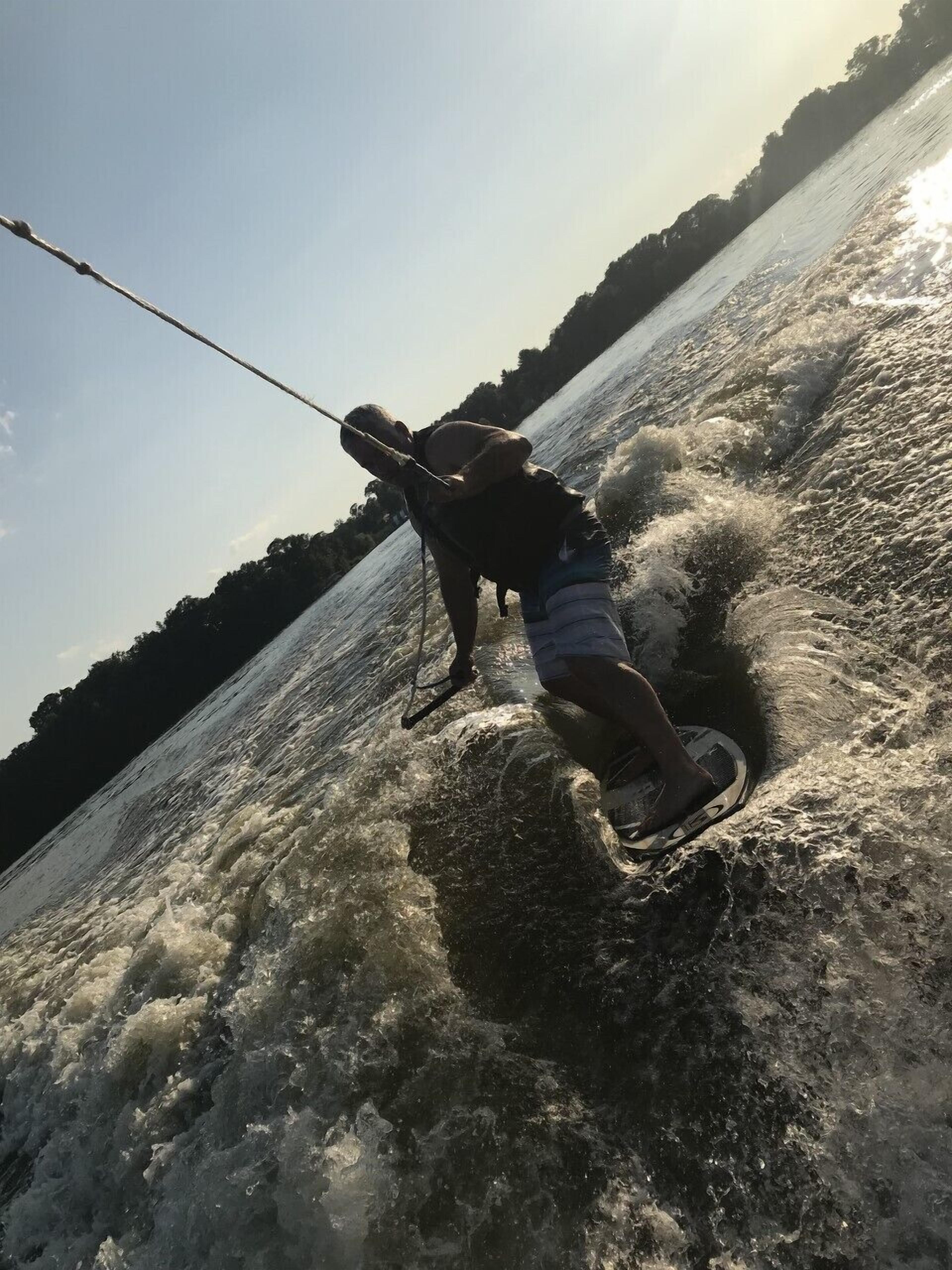 Una persona navegando en un vehículo acuático por un río con una cascada.