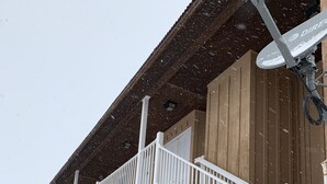 Ein Holzhaus mit einer Veranda und einer weißen Treppe, die zum Eingang führt.