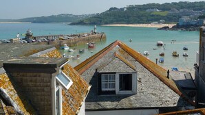 A coastal town with a harbor, buildings with sloped roofs, and a clear view of the sea. - 3 Victoria House, St Ives – Sleeps 4 – Sea Views (St Ives)