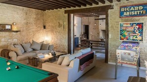 A cozy living room with a pool table, a sofa, and a game machine. - Charming B&B close to the D-day beaches and to Bayeux (Mosles)
