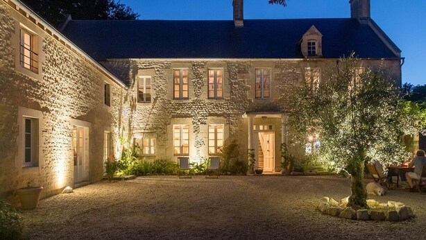 A stone building with multiple windows and a covered patio area. - Charming B&B close to the D-day beaches and to Bayeux (Mosles)