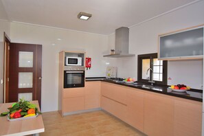 Enjoy cooking in this well-equipped kitchen with a microwave, stainless steel range hood, and sink.