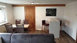 A compact living space with a dining area, a kitchenette, and a sofa. - HässelHof - Holiday apartment in the center of Bad Liebenwerda (Bad Liebenwerda)