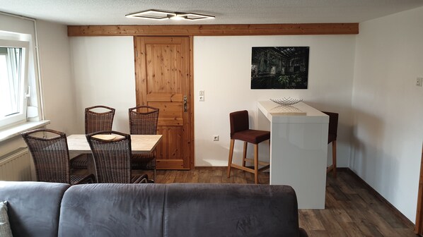 A compact living space with a dining area, a kitchenette, and a sofa. - HässelHof - Vacation Apartment in Downtown Bad Liebenwerda (Bad Liebenwerda)