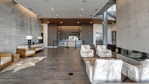 A spacious lobby with a reception desk, seating area, and a modern kitchen in the background.