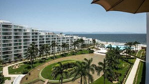 Ein Hotel mit mehreren Etagen, einem Pool und Palmen.