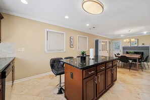 A modern kitchen with a central island, dark wooden cabinets, and a beige wall. - Stylish Stone Mountain home, sleeps 8 (Stone Mountain)