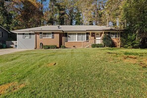 A two-story house with a brick facade, a front porch, and a well-maintained lawn.
