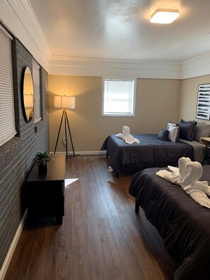A hotel room with two beds, a standing lamp, a mirror, and a window with blinds. - Stylish Stone Mountain home, sleeps 8 (Stone Mountain)