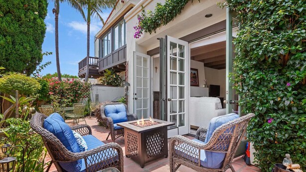 A patio with wicker furniture, a fire pit, and a view of the building's interior. - Enjoy the Beauty of Downtown Santa Barbara Walk Everywhere! (Santa Barbara)