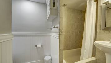 A bathroom with a bathtub, a shower, a toilet, and a sink.