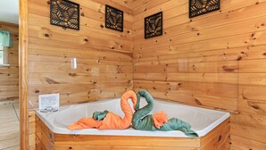 A wooden cabin with a large bathtub, wooden walls, and decorative cutouts. - Smokin Sunrise Cabin (Cosby)