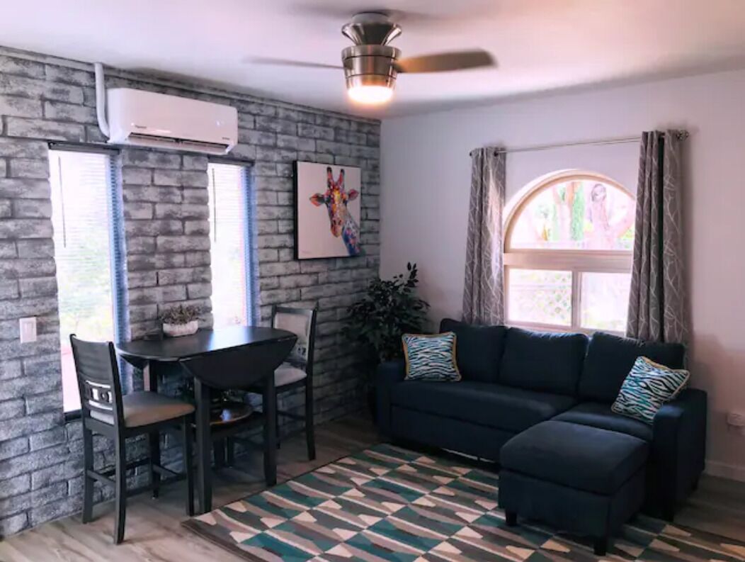 Living area with dining/work space, plenty of outlets, and cozy modern seating.