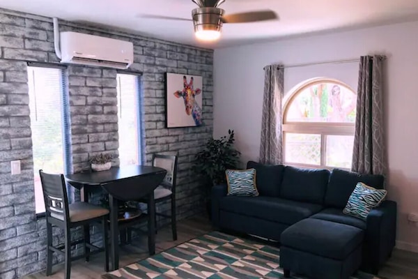 Living area with dining/work space, plenty of outlets, and cozy modern seating.