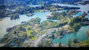 An aerial view of a coastal area with multiple islands, a river, and a bridge connecting them. - an anchor for the soul (Guatape)