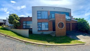 A modern two-story building with a brick facade, large windows, and a circular architectural feature. - Spectacular Views of the bay -Bay View Witsand (Witsand)
