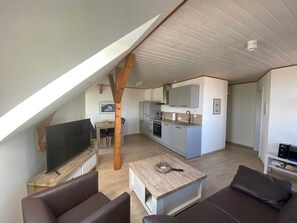 Un appartement moderne de style « loft » comprenant un coin repas, une cuisine et un espace de vie.
