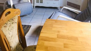 A living room with a sofa, a dining table, a TV, a cabinet, and a plant. - Apartment no.2 climatic health resort, pearl of the Neckar valley (Hirschhorn am Neckar)