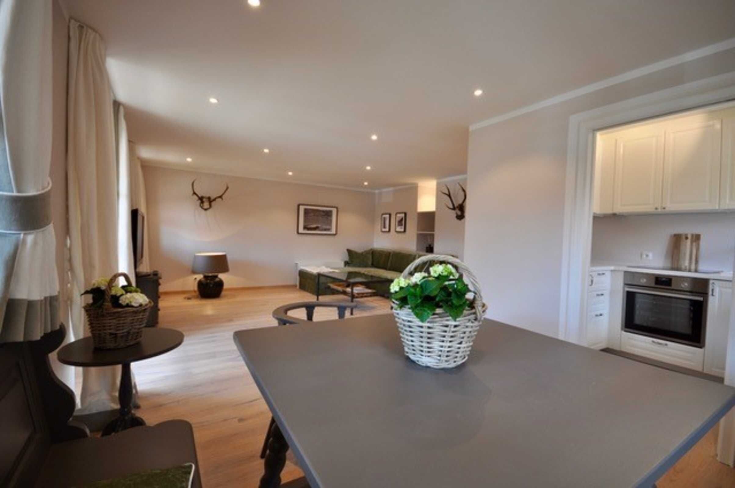 Una sala moderna con una mesa de comedor, sofá y zona de cocina.