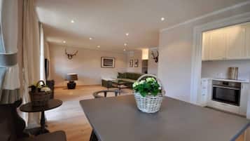 Una sala moderna con una mesa de comedor, sofá y zona de cocina.