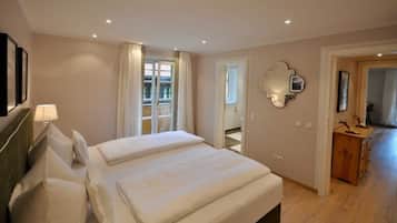 Ein Hotelzimmer mit einem Bett, einem Spiegel, einem Schminktisch und einer Tür, die auf einen Balkon führt.