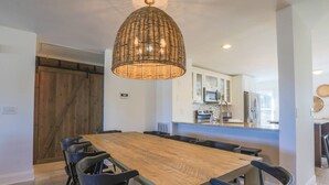 A modern kitchen with white cabinets, a wooden dining table, and black chairs. - 2 Mins to Beach; Community Pool & Pickleball; Dog Friendly; Walk to Grocery, Shops & Restaurants! (Isle of Palms)