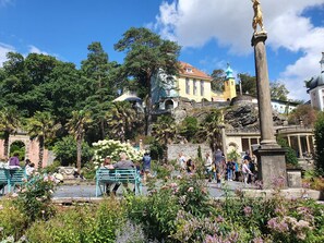 Une place publique avec des bancs, une fontaine et une statue.
