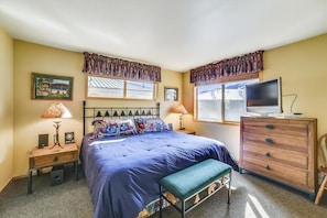A bedroom with a bed, two bedside tables, a dresser, a television, and a window with curtains. - Lagoon 736d 2 Bedroom Townhouse by RedAwning (Frisco)