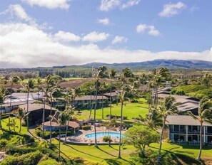Ein Resort mit mehreren Gebäuden, einem Swimmingpool und Palmen.