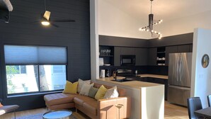 A modern living room with a sofa, a coffee table, and a rug. - Bohemian Sunrise  (Englewood)