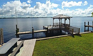 Relax on the lakeside dock, surrounded by a serene grassy area and a tranquil shoreline.