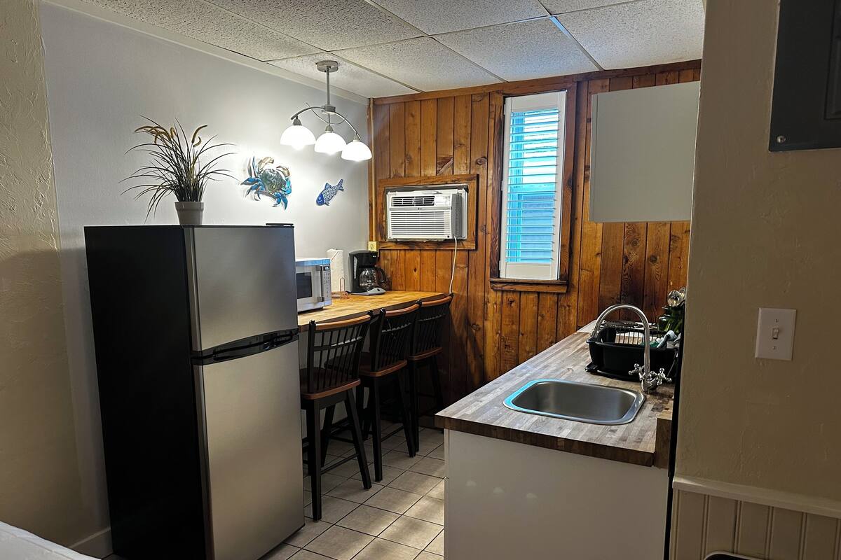A compact kitchen with a refrigerator, microwave, and sink.