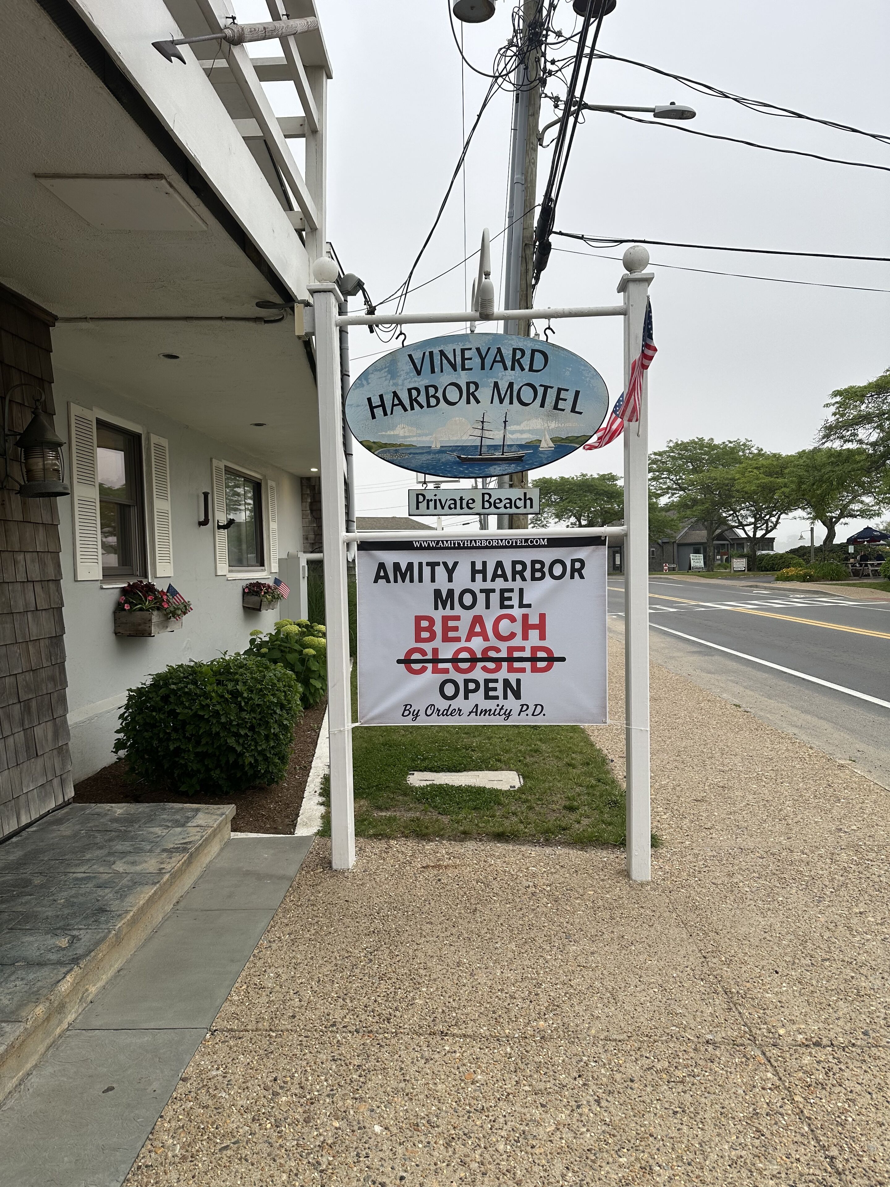 Schild des Vineyard Harbor Motel mit Privatstrand. Es steht darauf, dass es geschlossen, aber auf Anordnung geöffnet ist.