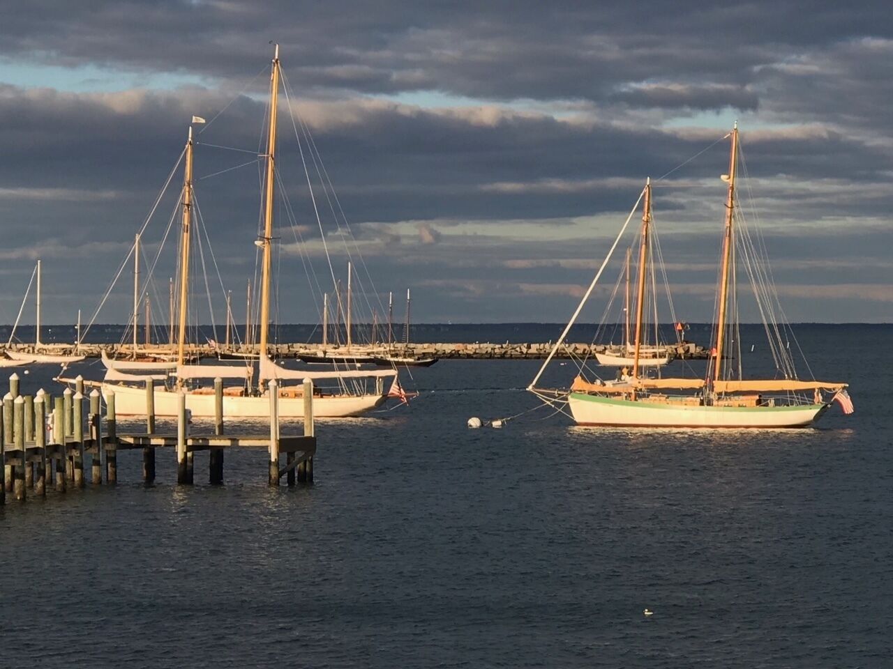 A marina with several sailboats docked at wooden piers.