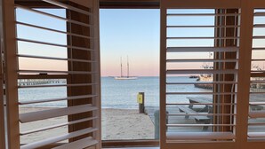 A room with a view of a beach, a pier, and a sign indicating no swimming. - Vineyard Harbor Motel - Private Beach (Vineyard Haven)