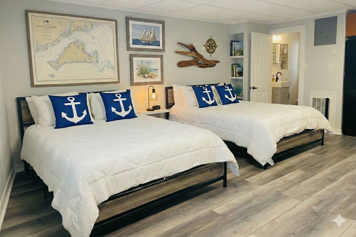 A bedroom with two beds, nautical-themed decor, a map, and a compass on the wall.