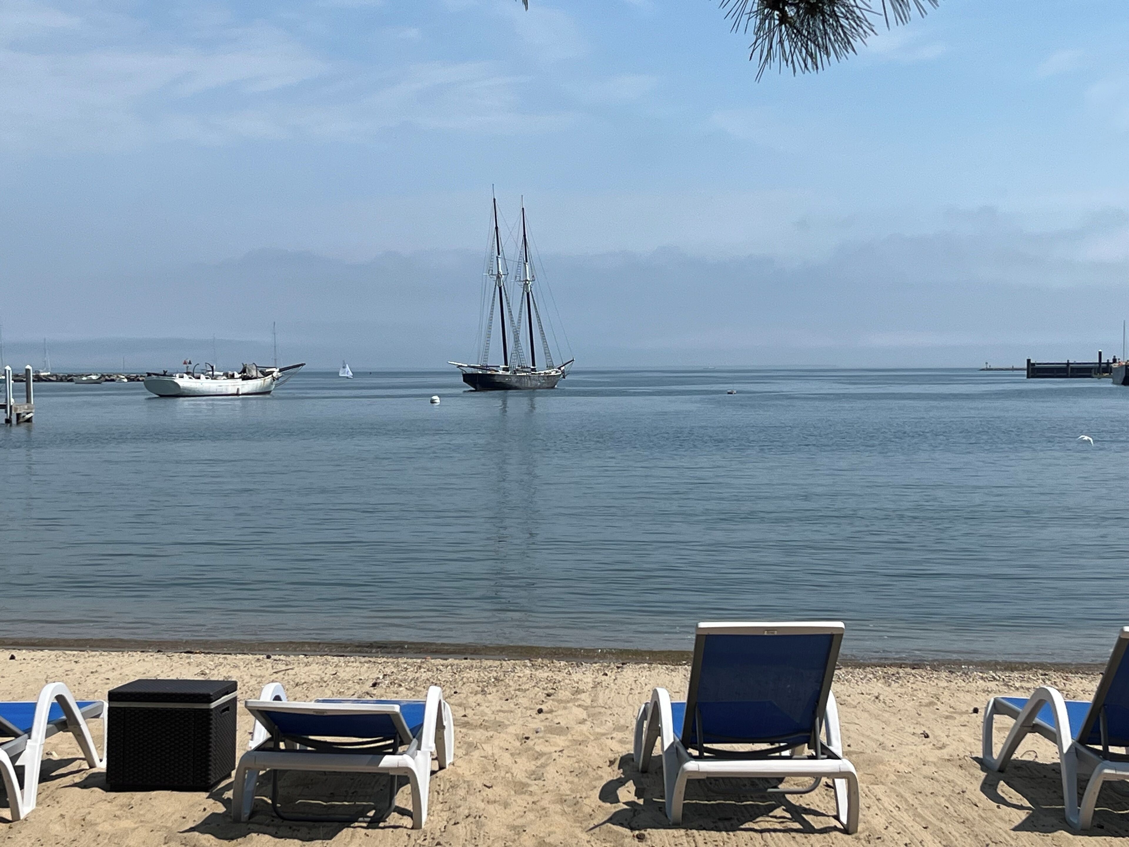 Una playa con sillas de descanso y un mar tranquilo.