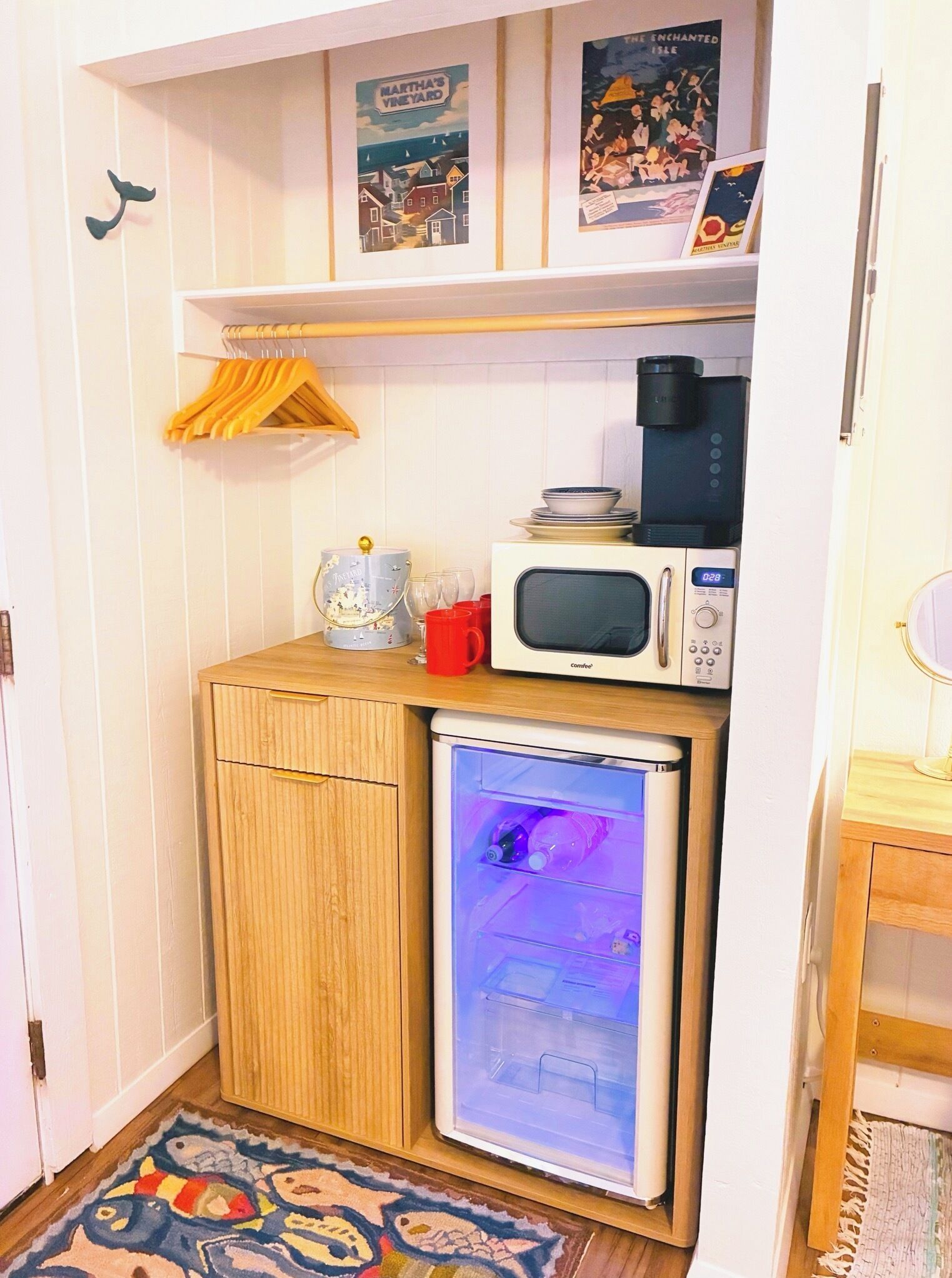 Een kleine keuken met een koelkast, magnetron en koffiezetapparaat.